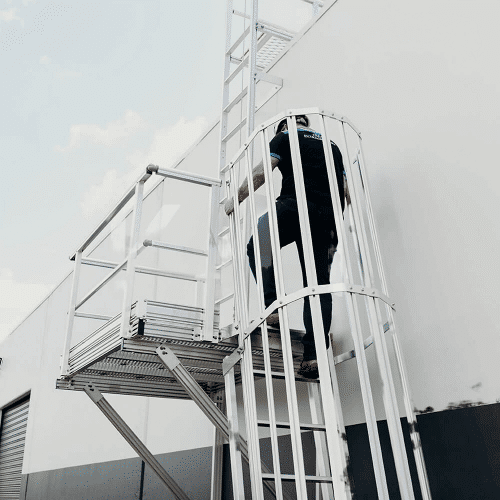 Worker climbing stairs to access anchor points at the roof